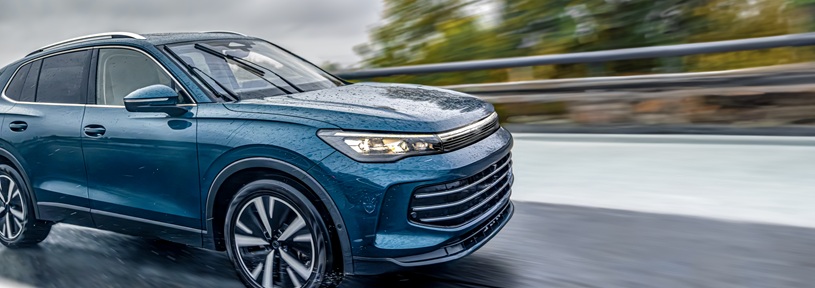 Modern blue SUV driving fast on a wet rainy road, symbolizing power, innovation, and the elegant motion of future automotive design.